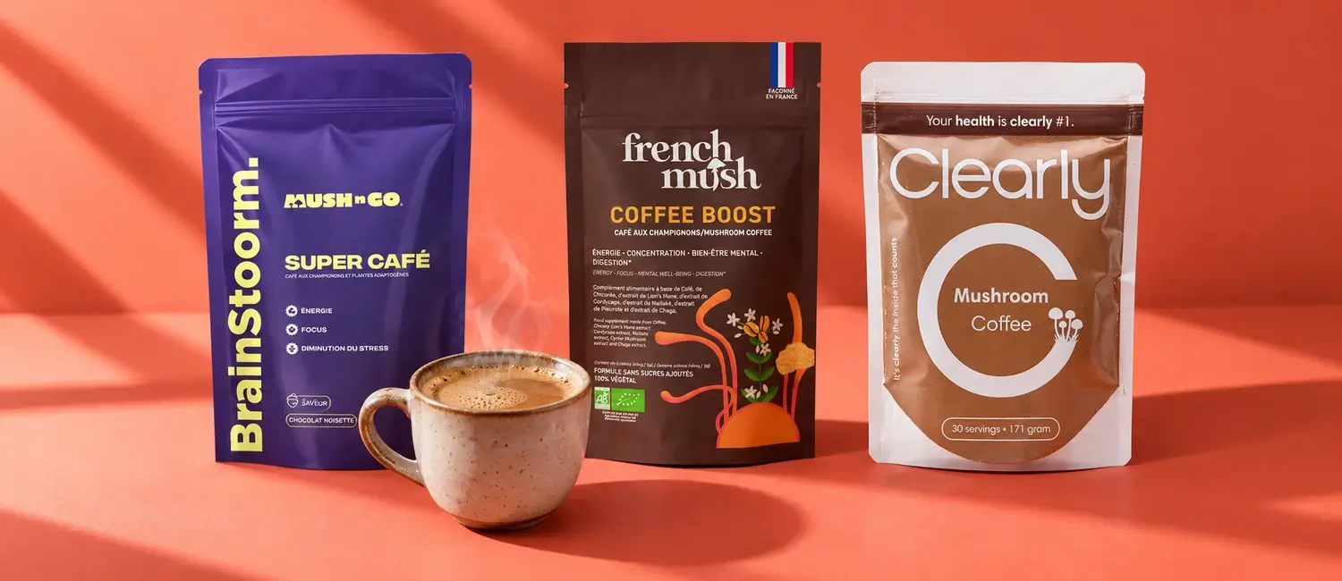 Confezioni di Brainstoorm, French Mush Boost Caffè e Clearly Mushroom Coffee con una tazza fumante su fondo corallo